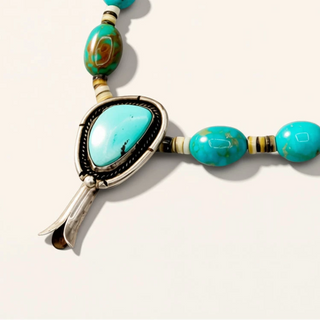 turquoise beaded necklace with turquoise pendant on a beige background