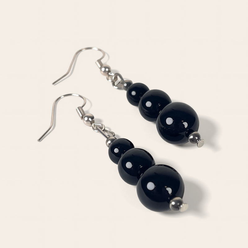 Pair of black beaded earrings on a white background