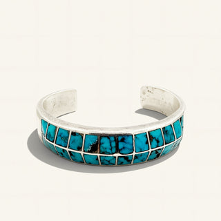 silver cuff with turquoise stones on a beige background