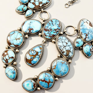 turquoise stone silver jewelry on a beige background