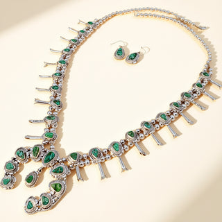 Jewelry set with necklace and earrings featuring green gemstones on a beige background