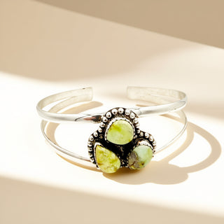 Silver cuff with three yellow stones on a beige background