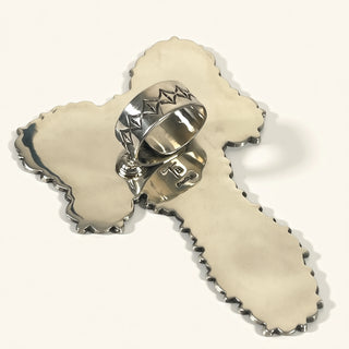 Silver ring with star design on a decorative white surface