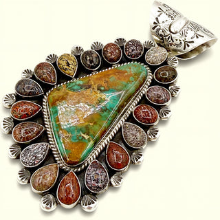 Silver pendant with a large green stone and smaller brown stones on a white background