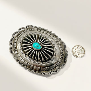 Silver buckle and coin on a beige background