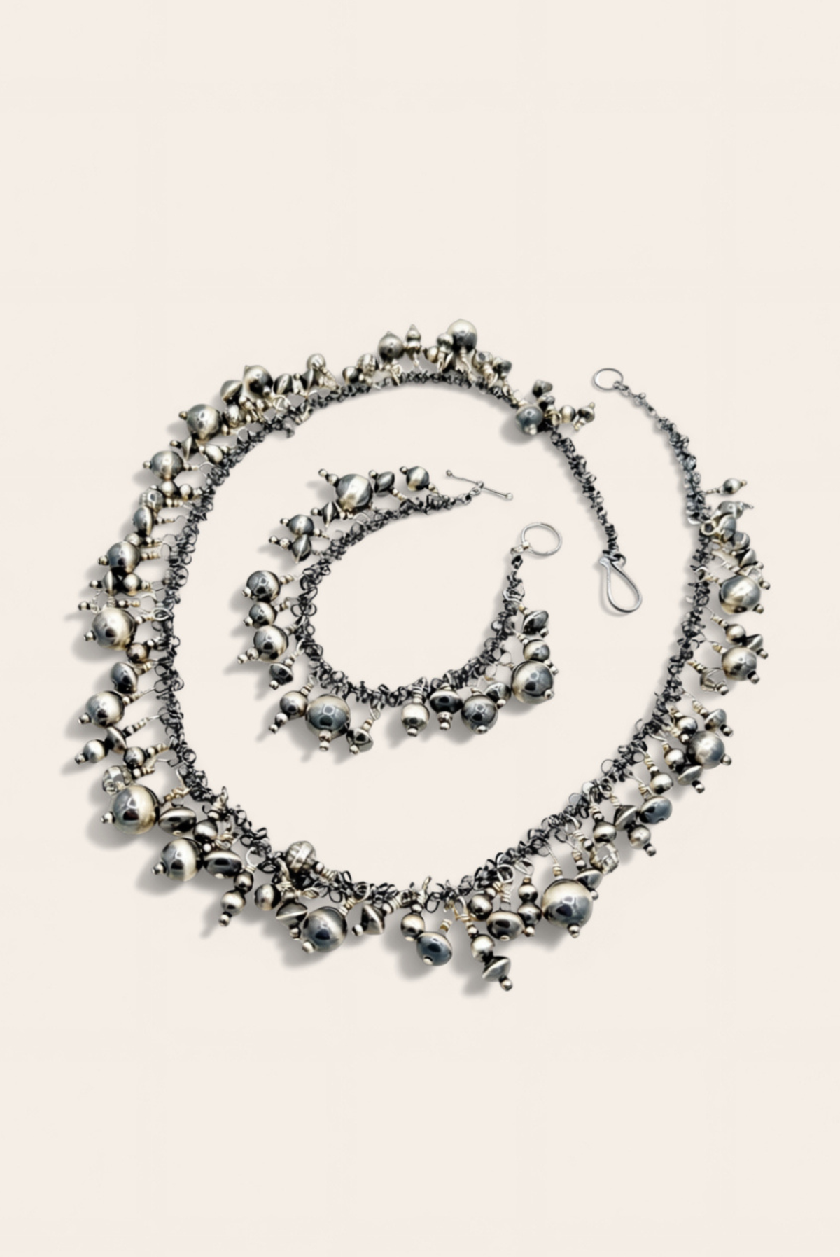 Silver necklace with star-shaped pendants on a light background