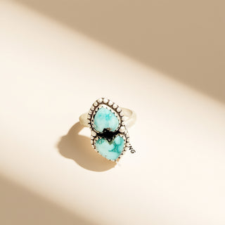 Ring with turquoise stones on a beige background