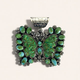 Jewelry pendant with green butterfly design and embedded stones on a beige background