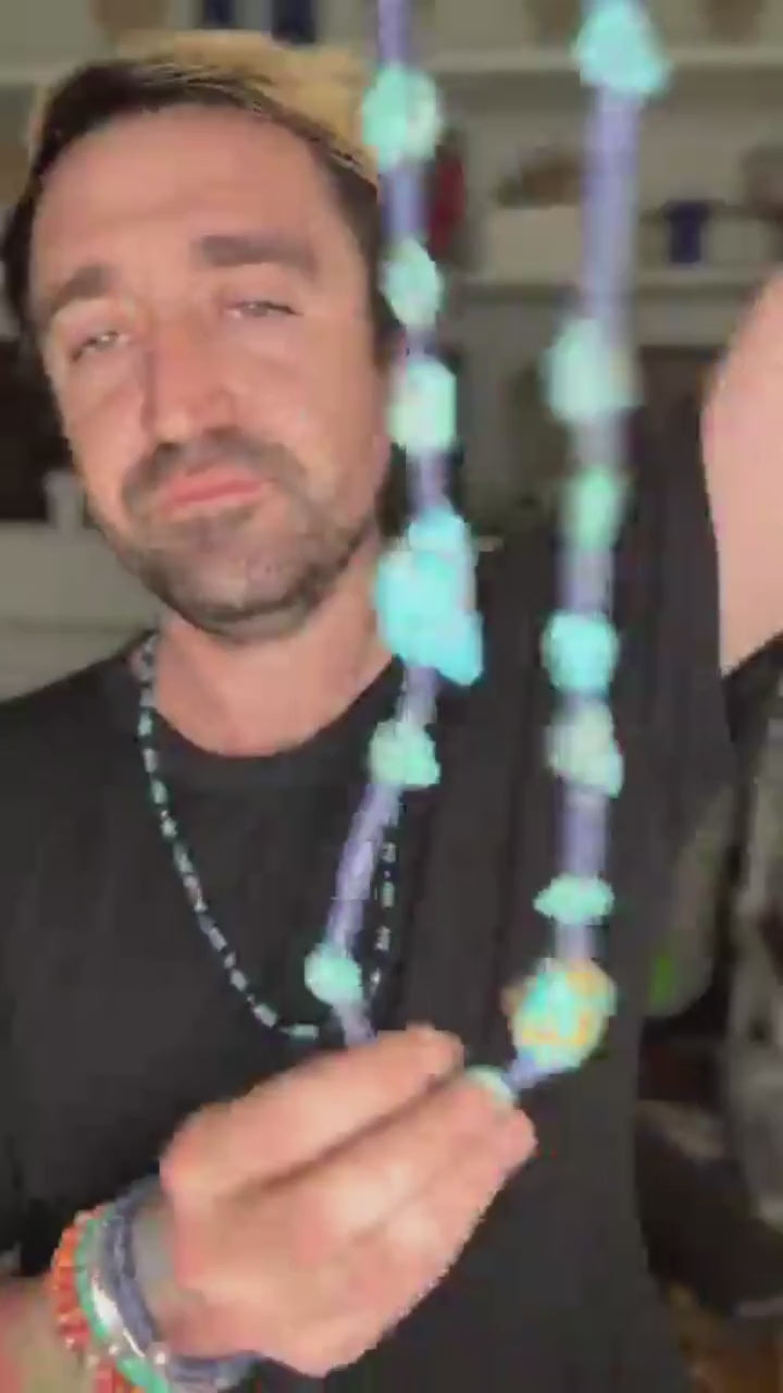 video of man displaying turquoise necklace 