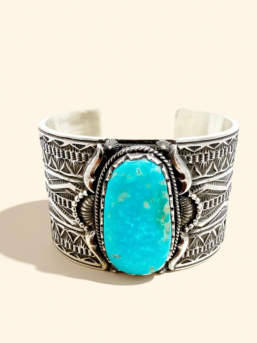 Silver cuff bracelet with turquoise stone on a light background